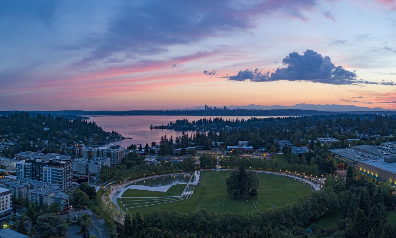 Aerial view of a lakeside city and park at sunset